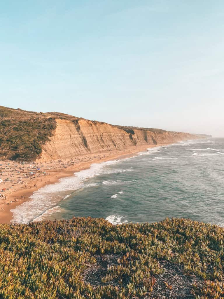 Image of Sintra beaches Portugal Praia do Magoito with greenery in the foreground and steep cliffs along the coast