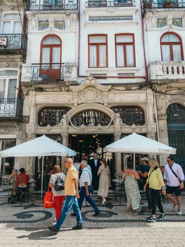 De mooie gevel van het Majestic Café in Porto en parasols op het terras