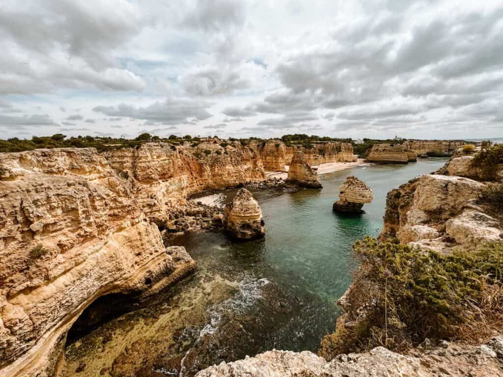 Een adembenemend uitzicht op Praia da Marinha Beach, met indrukwekkende rotsformaties die oprijzen uit het turquoise water en een prachtig landschap van kliffen en verborgen baaien langs de kust van de Algarve. Deze iconische plek staat bekend als een van de mooiste stranden ter wereld.