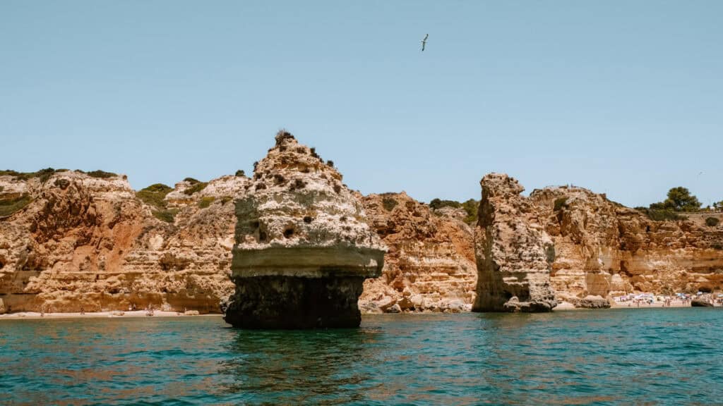 Rotsformaties aan de kust van de Algarve gezien vanaf het water tijdens een Grotten van Benagil boottocht op een zonnige dag.