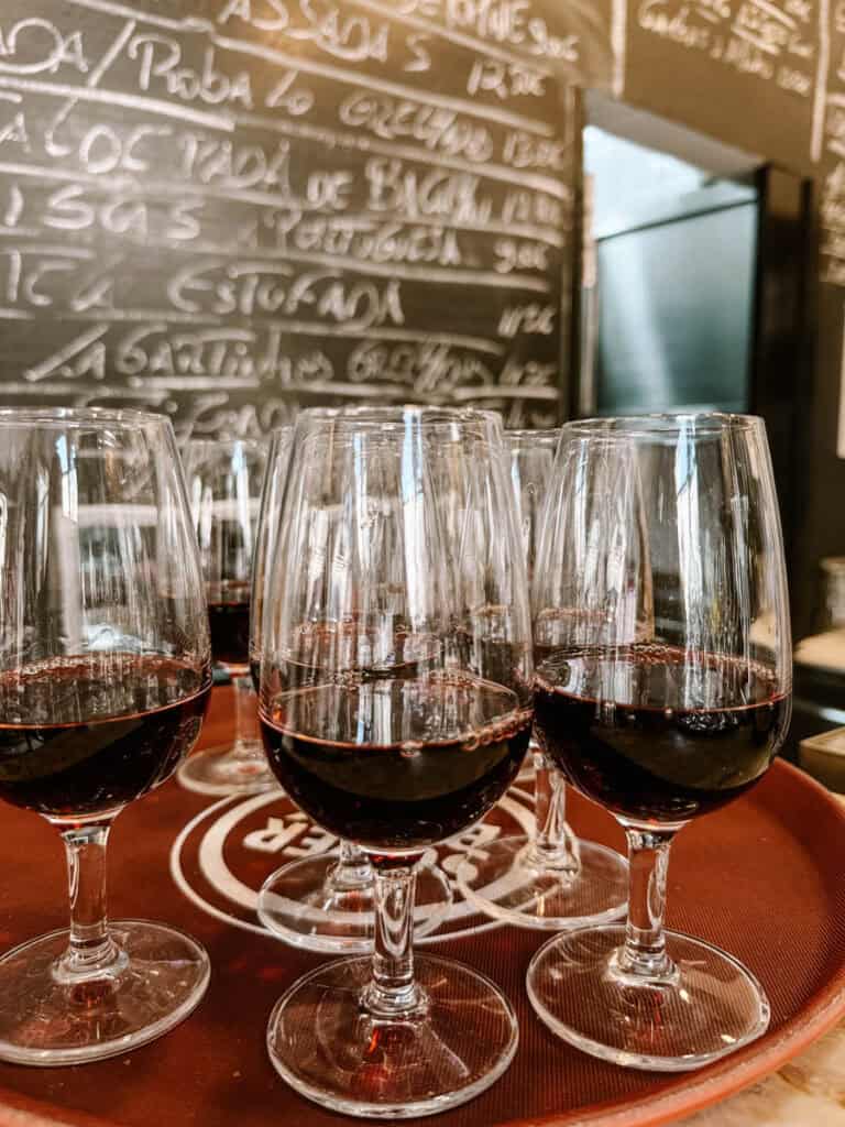 Várias taças com vinho tinto preparadas para uma degustação de vinhos portugueses num espaço interior em Lisboa. A experiência é uma das atividades em Lisboa com chuva para provar diferentes vinhos locais num ambiente descontraído.