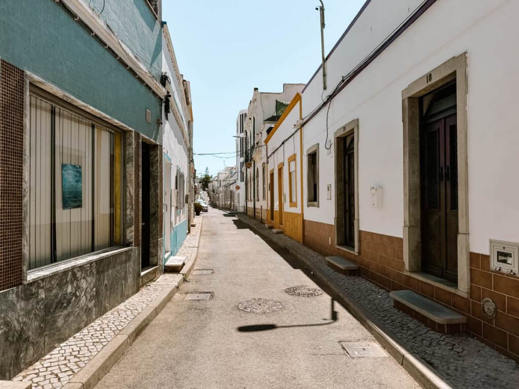 Narrow residential street in Fuseta with colourful facades and traditional houses creating a peaceful setting for exploring and everyday local life.