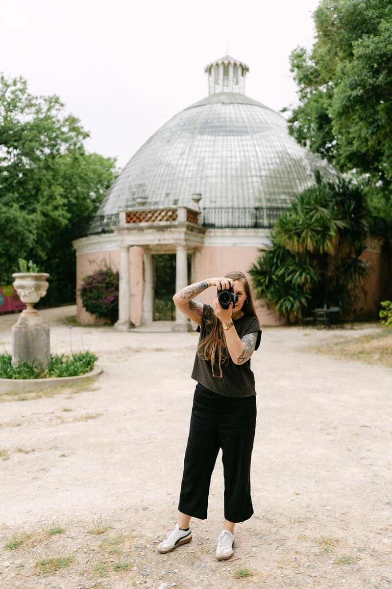 Lissabon fotograaf tijdens een fotoshoot voor een historische glazen koepel in een groene stadstuin.