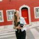 Fotograaf in Lissabon met een camera voor een karakteristiek rood Portugees gebouw.