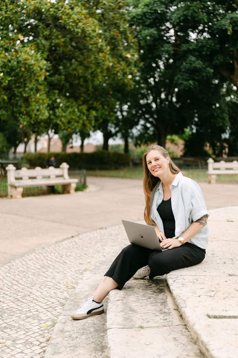 Portugal reisplanner in Lissabon werkt met een laptop aan een persoonlijke reisplanning in een groen stadspark.
