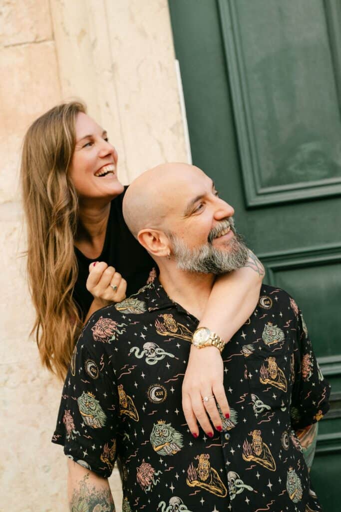 Ulisses en Marga van Discover Portugal lachen samen voor een karakteristieke groene deur in Lissabon.